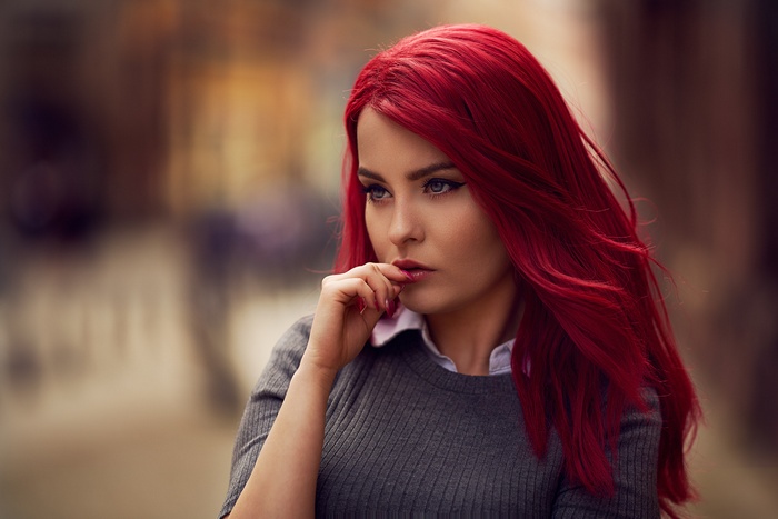 Redhead woman with hand on mouth looking away