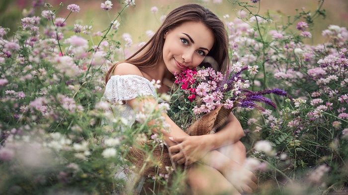 Woman in a field of flowers holding a bouquet