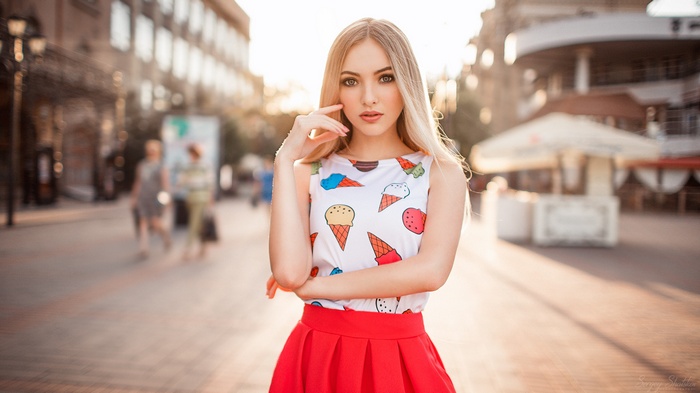 Woman in ice cream print top and red skirt outdoors