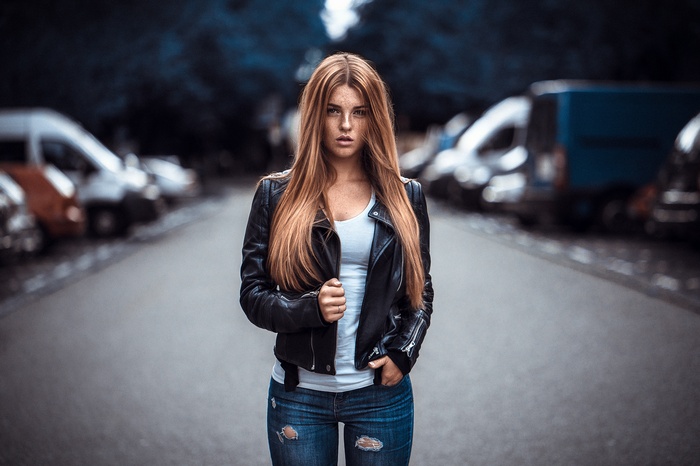 Woman with freckles wearing a leather jacket and torn jeans
