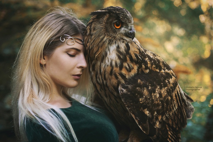 Woman with an owl in a forest