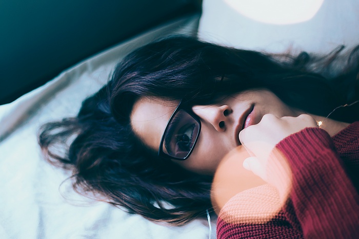 Woman with glasses lying down