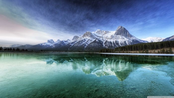 Snow-capped mountains reflected in a clear lake