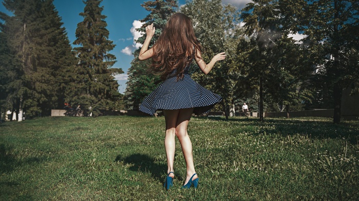 Woman in polka dot dress dancing in park