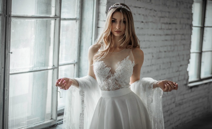 Woman in a white wedding dress by a window