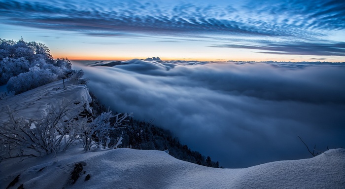 Winter mountain landscape with clouds at sunrise