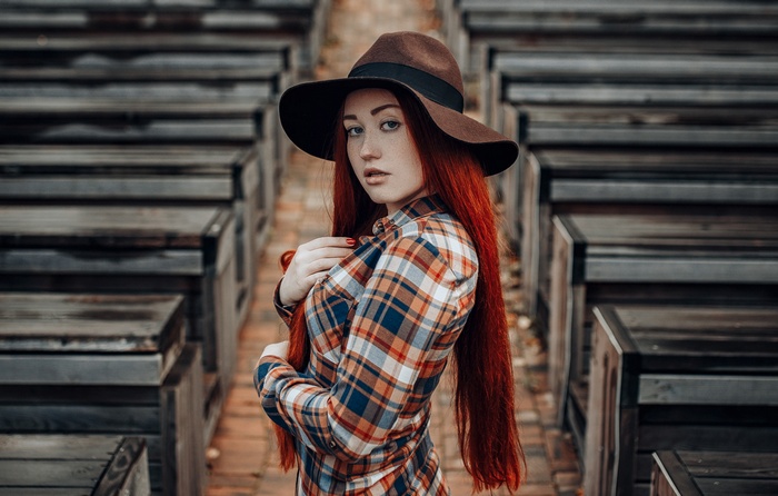 Redhead woman wearing a hat and plaid shirt