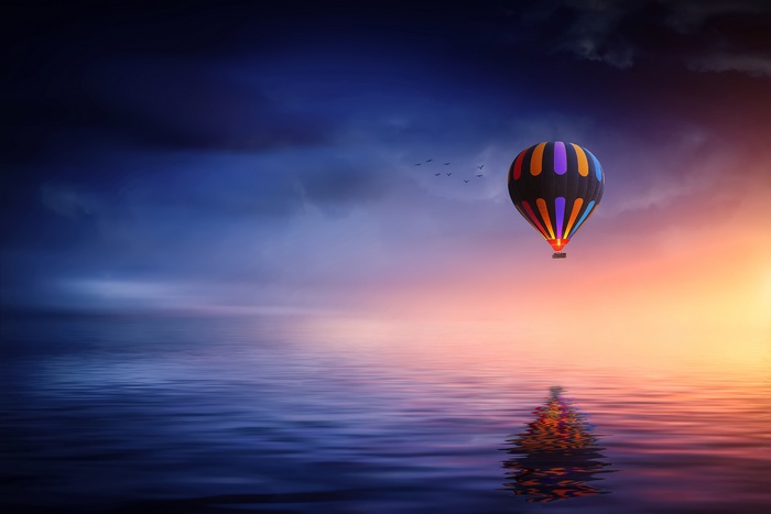 Hot air balloon over the sea at sunset