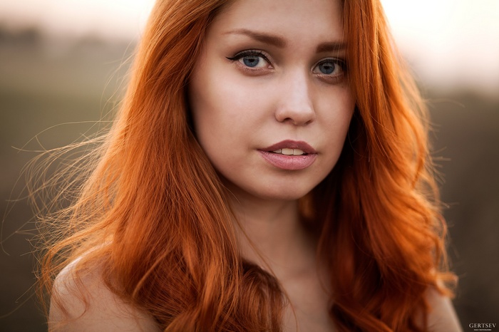 Close-up portrait of a redhead woman with blue eyes