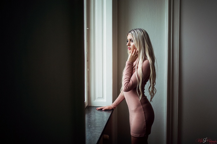 Woman with long blonde hair by the window