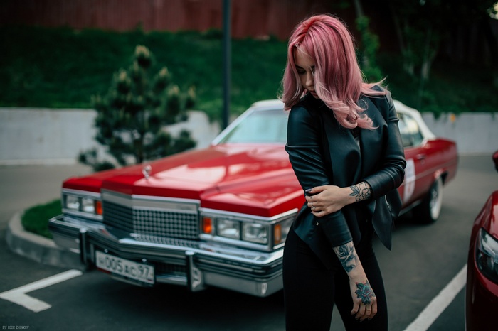 Woman with tattoos and a red Cadillac