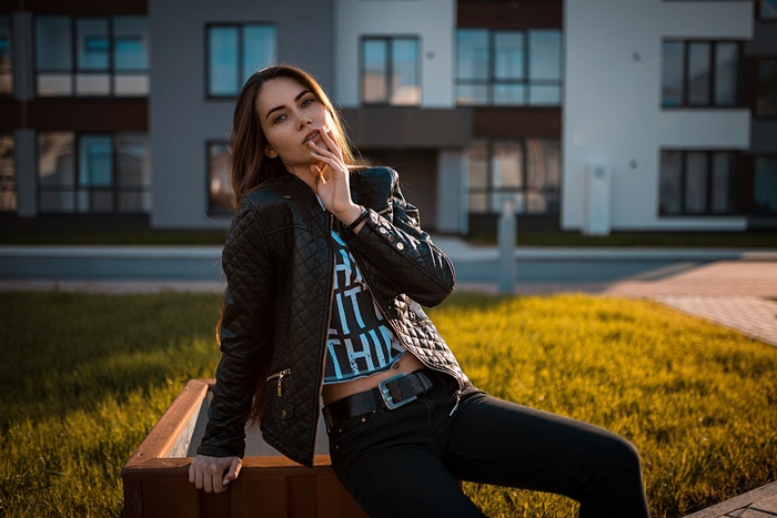 Woman in leather jacket with finger on lips