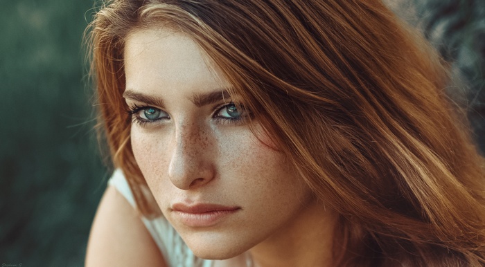 Portrait of a young woman with freckles and red hair