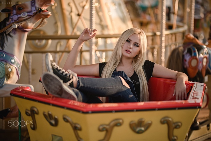 Woman with blonde hair sitting in a carousel car