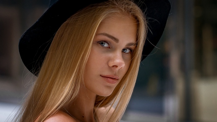 Woman with blonde hair wearing a black hat