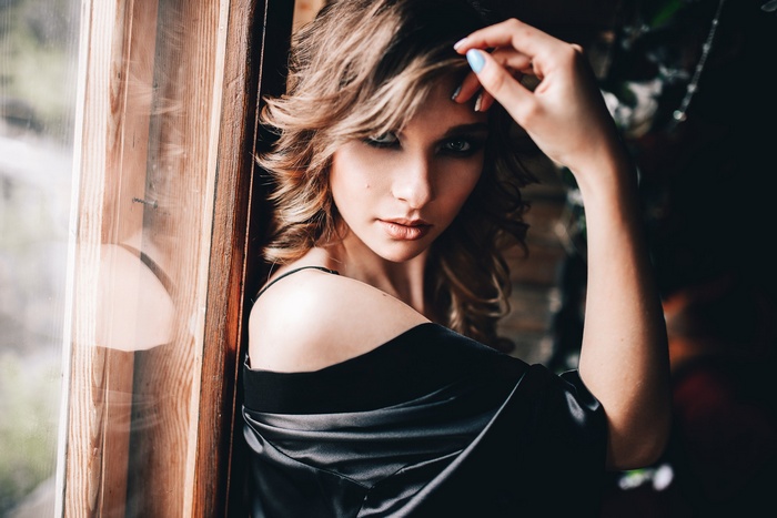 Woman in black lingerie by a window