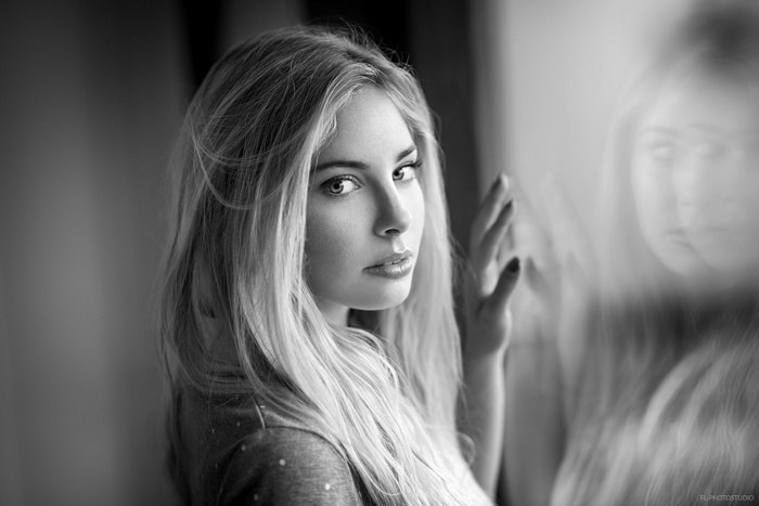 Monochrome portrait of a woman looking at her reflection