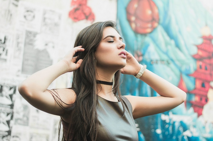 Woman with hands in hair wearing choker