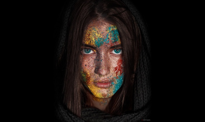Woman with colorful paint on face and blue eyes