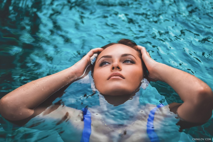 Woman with hands on head in water