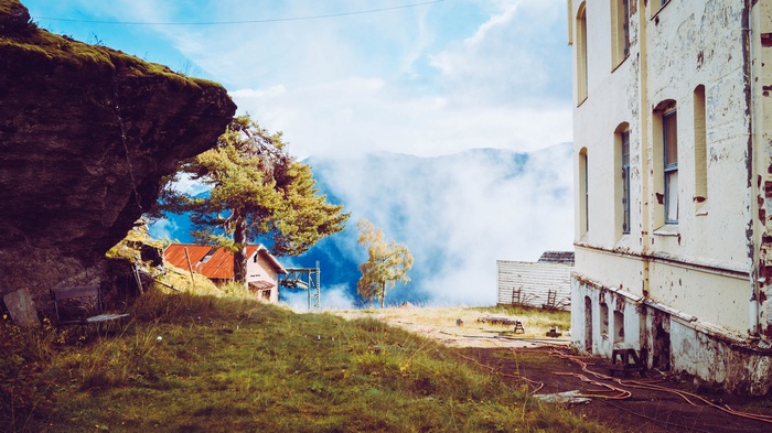 Abandoned building and cabin in misty Norwegian landscape