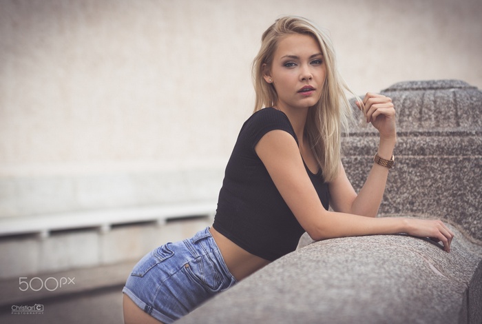 Woman in jean shorts and black top outdoors