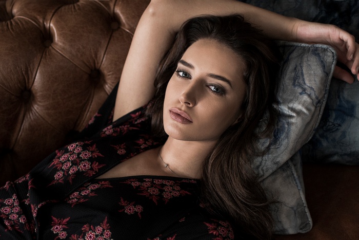 Woman lying on a leather couch