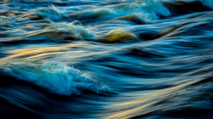 Long exposure of blue ocean waves with golden light