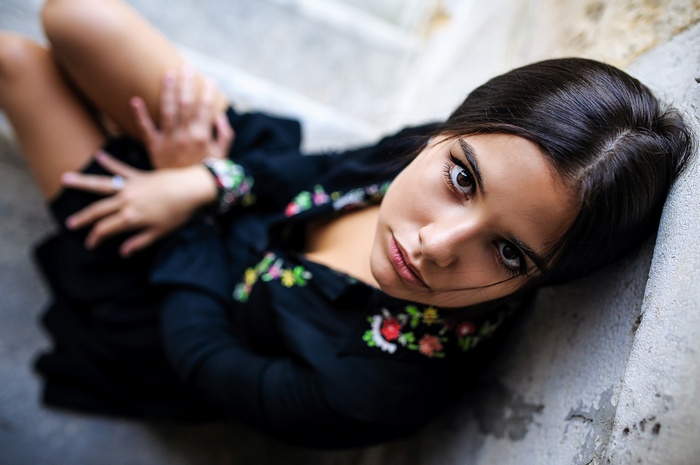 Woman sitting on stairs with embroidered dress