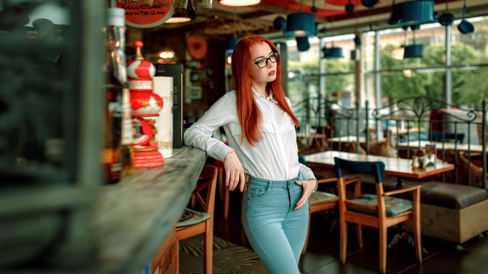 Woman with red hair and glasses in a cafe