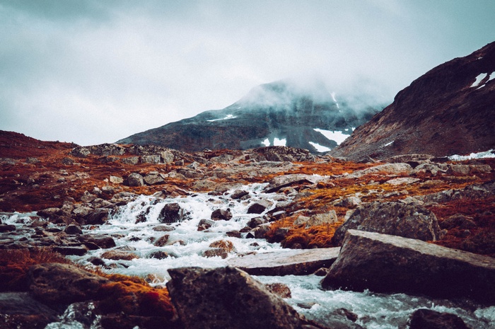 Rocky mountain landscape with a river and mist