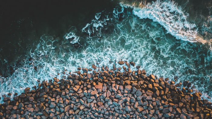 Aerial view of waves crashing on a rocky coastline