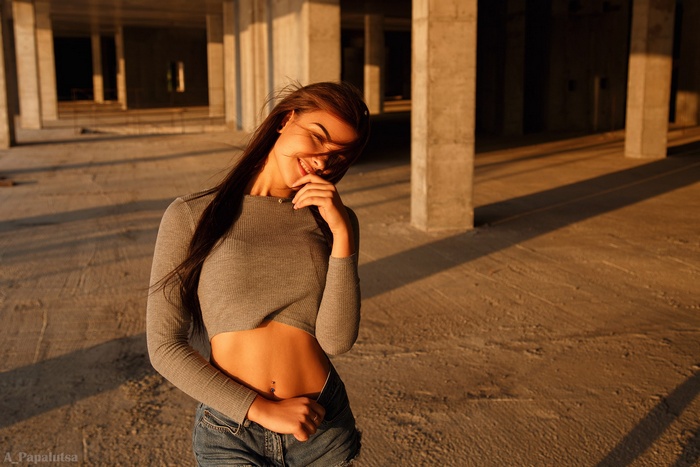 Woman in crop top and jean shorts smiling