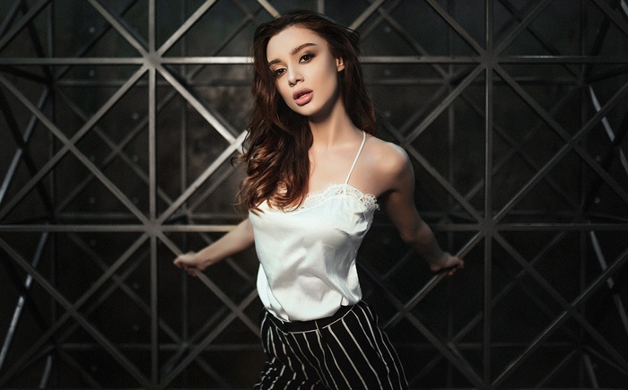 Tanned woman in white top and striped pants