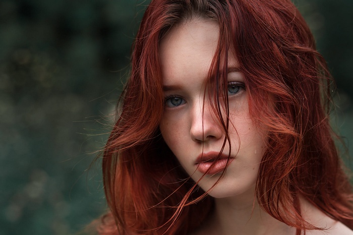 Redhead woman with blue eyes and hair in face