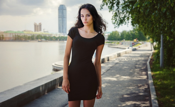 Woman in black dress by the water