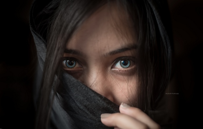 Woman with blue eyes wearing a dark headscarf