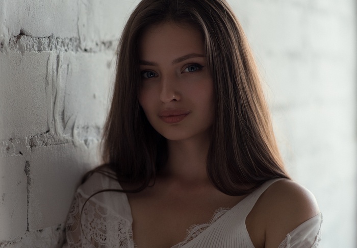 Portrait of Veronika Avdeeva leaning against a brick wall
