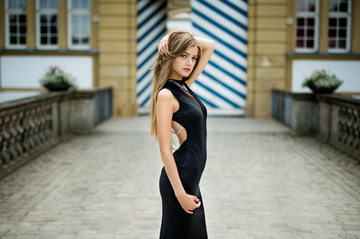 Woman in black dress with hands in hair