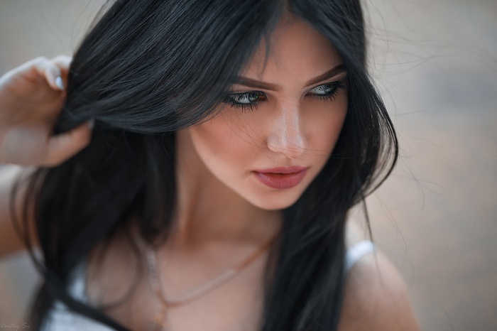 Woman with dark hair wearing a necklace