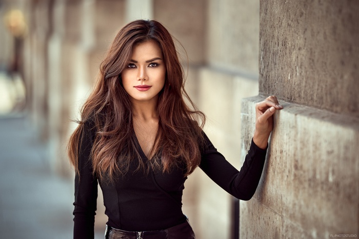 Woman with long brown hair in black clothing outdoors