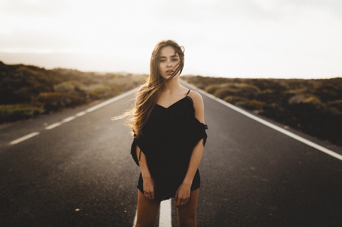 Woman in black shirt standing on a road