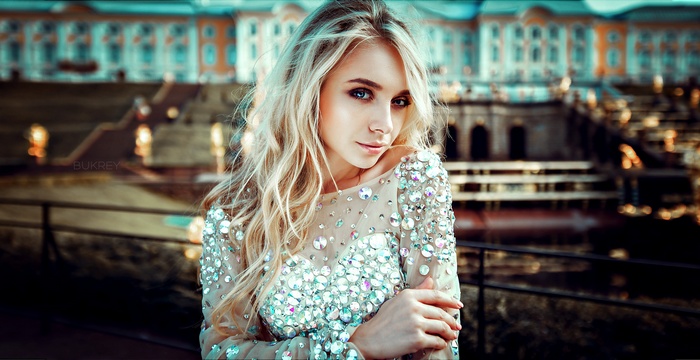 Woman with blonde hair and blue eyes in a jeweled dress