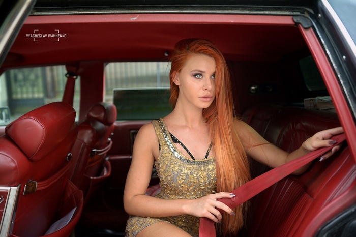 Redhead woman in a dress inside a car