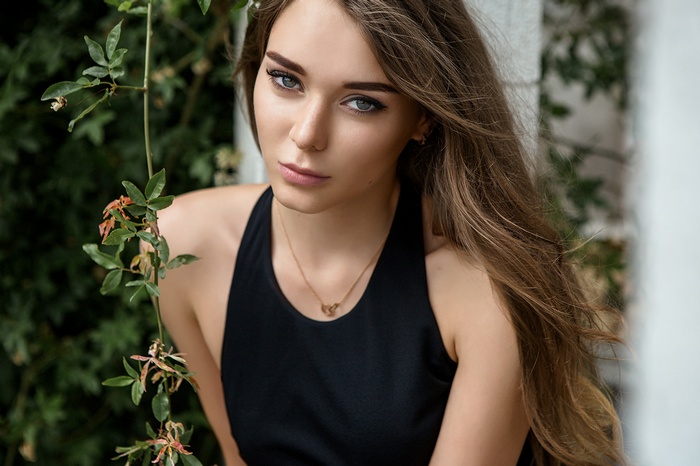 Woman with long brown hair wearing a black top