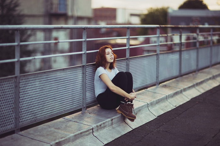 Isabela Mayer sitting on a ledge with eyes closed