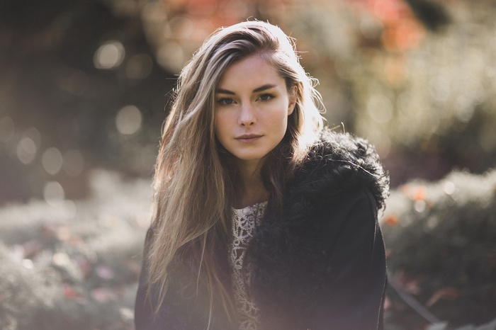 Woman with long blonde hair wearing a black coat