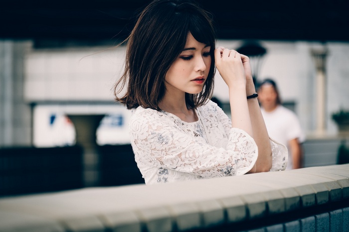 Asian woman with dark hair wearing a white lace top