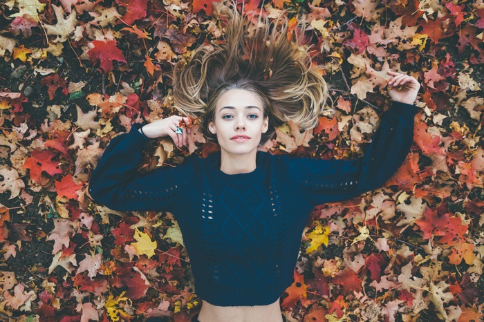 Woman lying on autumn leaves