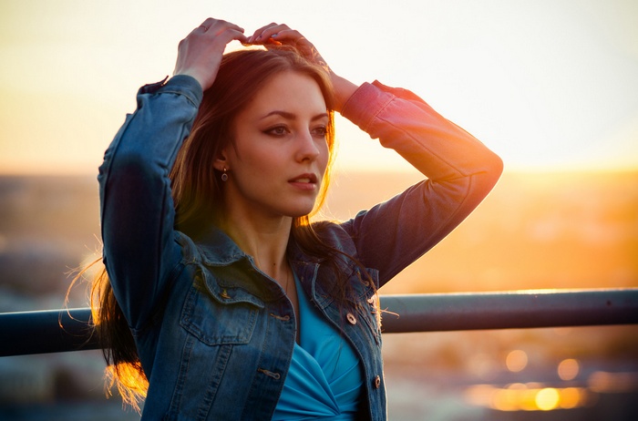 Woman in denim jacket at sunset